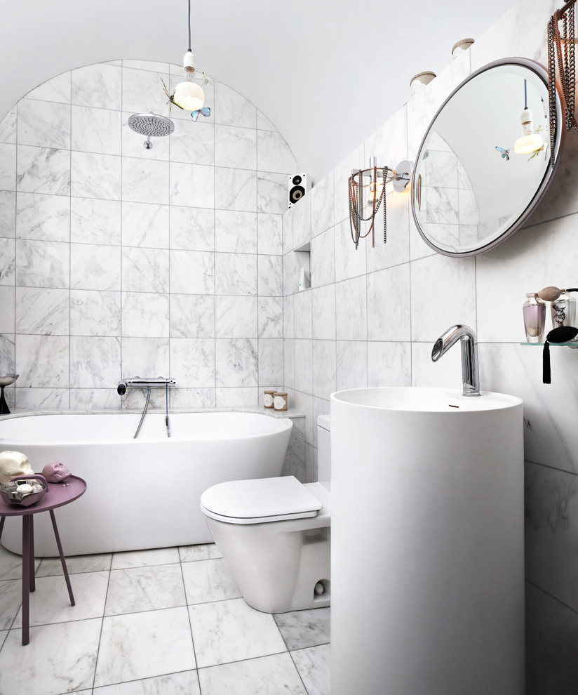 Photo of a bohemian bathroom in Toronto with a freestanding bath, a shower/bath combination, a one-piece toilet, white tiles and white walls.