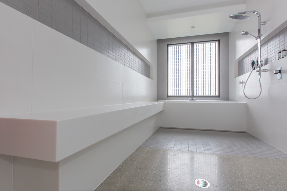 Exempel på ett litet modernt en-suite badrum, med släta luckor, skåp i mellenmörkt trä, ett platsbyggt badkar, en öppen dusch, en toalettstol med separat cisternkåpa, grå kakel, porslinskakel, vita väggar, betonggolv, ett undermonterad handfat och bänkskiva i akrylsten
