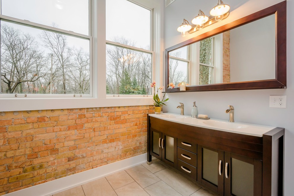 На фото: главная ванная комната среднего размера в современном стиле с стеклянными фасадами, темными деревянными фасадами, отдельно стоящей ванной, угловым душем, раздельным унитазом, бежевой плиткой, керамогранитной плиткой, серыми стенами, полом из керамогранита, монолитной раковиной, серым полом, душем с распашными дверями, серой столешницей, тумбой под две раковины, встроенной тумбой и кирпичными стенами