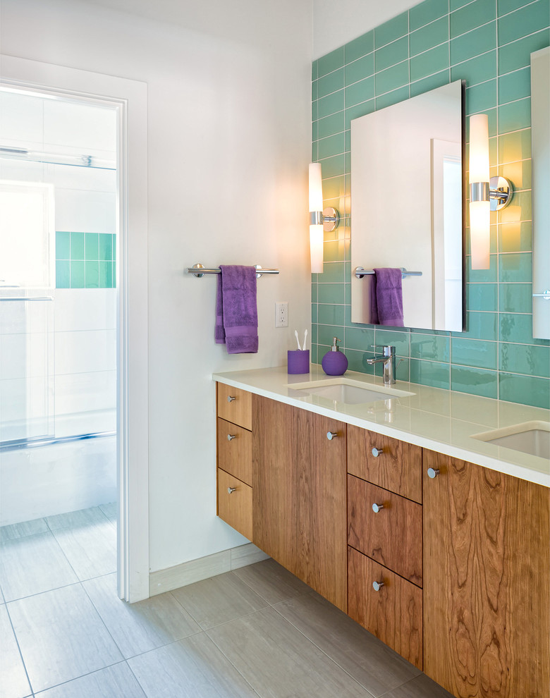 This is an example of a contemporary bathroom in Denver with a submerged sink, flat-panel cabinets, medium wood cabinets and green tiles.