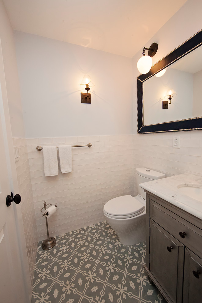 Стильный дизайн: ванная комната среднего размера в стиле неоклассика (современная классика) с фасадами с выступающей филенкой, серыми фасадами, ванной в нише, душем над ванной, раздельным унитазом, плиткой кабанчик, синими стенами, врезной раковиной, мраморной столешницей и душевой кабиной - последний тренд