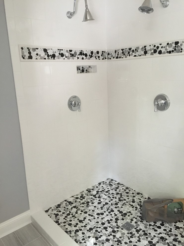 Bild på ett mellanstort vintage badrum med dusch, med luckor med infälld panel, vita skåp, ett fristående badkar, en dusch i en alkov, vit kakel, porslinskakel, ett undermonterad handfat, marmorbänkskiva, grå väggar och klinkergolv i porslin
