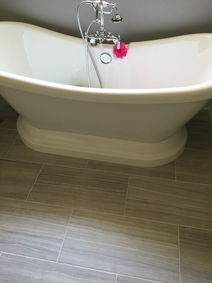 Klassisk inredning av ett mellanstort badrum med dusch, med luckor med infälld panel, vita skåp, ett fristående badkar, en dusch i en alkov, vit kakel, porslinskakel, grå väggar, klinkergolv i porslin, ett undermonterad handfat och marmorbänkskiva