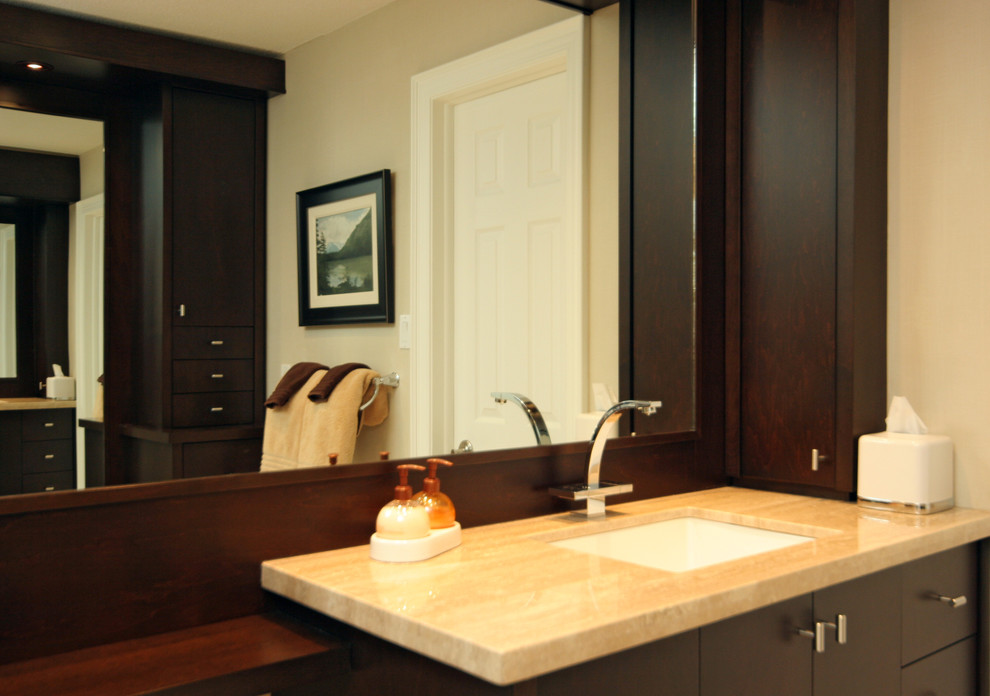 Стильный дизайн: главная ванная комната среднего размера в современном стиле с плоскими фасадами, темными деревянными фасадами, бежевыми стенами, врезной раковиной и столешницей из известняка - последний тренд