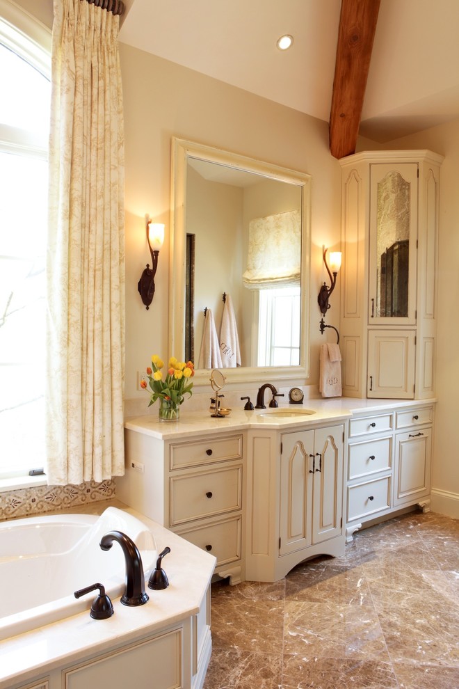 Idéer för att renovera ett mellanstort vintage badrum, med ett undermonterad handfat, möbel-liknande, beige skåp, marmorbänkskiva, beige kakel, porslinskakel, beige väggar, klinkergolv i porslin och ett platsbyggt badkar