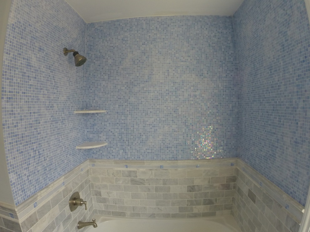 Idee per una stanza da bagno per bambini stile marino di medie dimensioni con lavabo sottopiano, ante in stile shaker, ante bianche, top in marmo, vasca da incasso, vasca/doccia, WC a due pezzi, piastrelle multicolore, piastrelle di vetro, pareti blu e pavimento in gres porcellanato