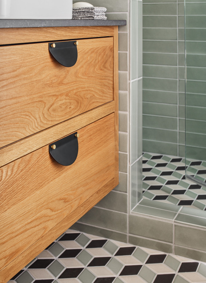 Retro inredning av ett mellanstort grå grått en-suite badrum, med skåp i ljust trä, en dusch i en alkov, grön kakel, keramikplattor, klinkergolv i keramik, flerfärgat golv och dusch med gångjärnsdörr