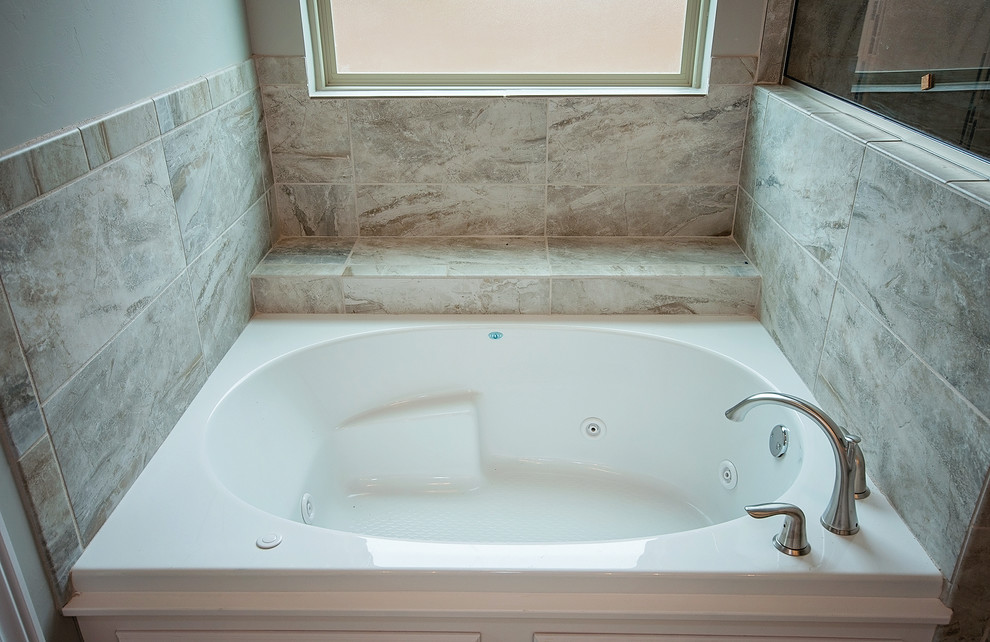На фото: большая главная ванная комната в стиле неоклассика (современная классика) с фасадами в стиле шейкер, белыми фасадами, накладной ванной, угловым душем, разноцветной плиткой, керамогранитной плиткой, серыми стенами, полом из керамогранита, врезной раковиной и мраморной столешницей