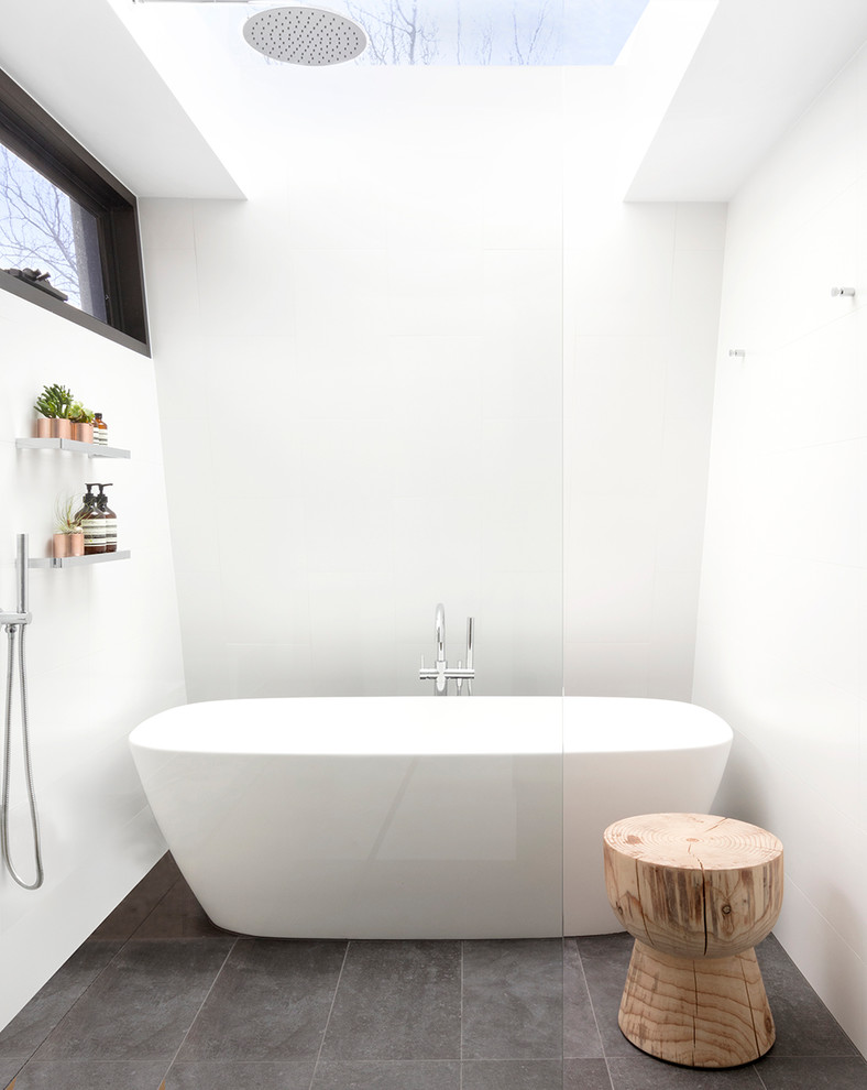 Imagen de cuarto de baño principal minimalista de tamaño medio con bañera exenta, paredes blancas, suelo de baldosas de porcelana, ducha abierta, ducha a ras de suelo y suelo gris