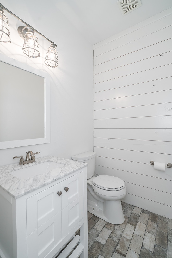 Imagen de cuarto de baño campestre de tamaño medio con armarios estilo shaker, puertas de armario blancas, suelo de baldosas de porcelana y suelo gris