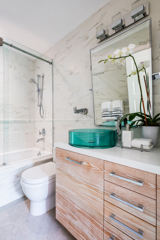 Exempel på ett mellanstort maritimt badrum, med släta luckor, skåp i ljust trä, ett badkar i en alkov, en dusch/badkar-kombination, en toalettstol med hel cisternkåpa, ett fristående handfat och bänkskiva i akrylsten