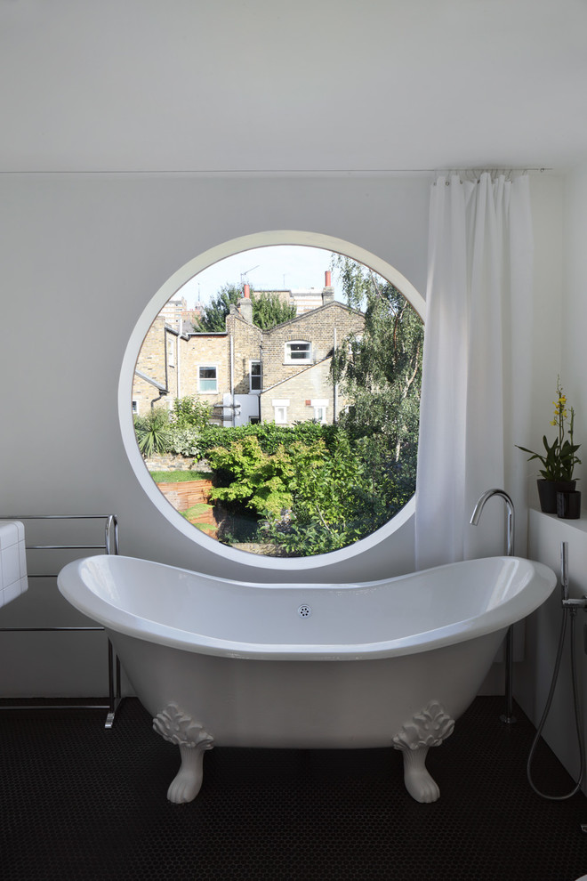 Foto de cuarto de baño tradicional con bañera con patas, paredes blancas y ventanas