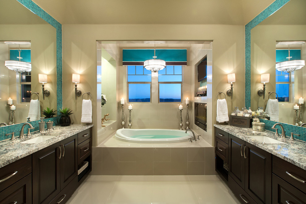 Idee per una stanza da bagno tradizionale con lavabo sottopiano, ante con bugna sagomata, ante in legno bruno, vasca da incasso, piastrelle blu e piastrelle a mosaico