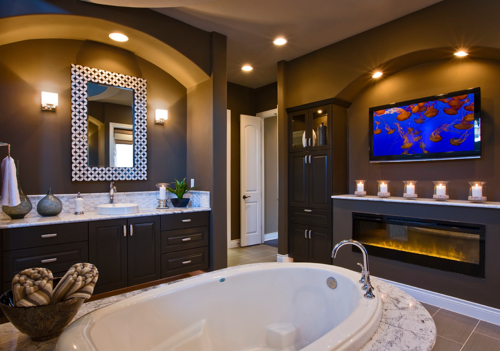 Example of a trendy drop-in bathtub design in Austin with a vessel sink