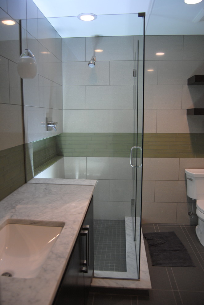 Idée de décoration pour une salle de bain principale minimaliste en bois foncé de taille moyenne avec un lavabo encastré, un placard à porte plane, un plan de toilette en marbre, une douche d'angle, WC séparés, un carrelage gris, un carrelage en pâte de verre, un mur gris et un sol en carrelage de porcelaine.