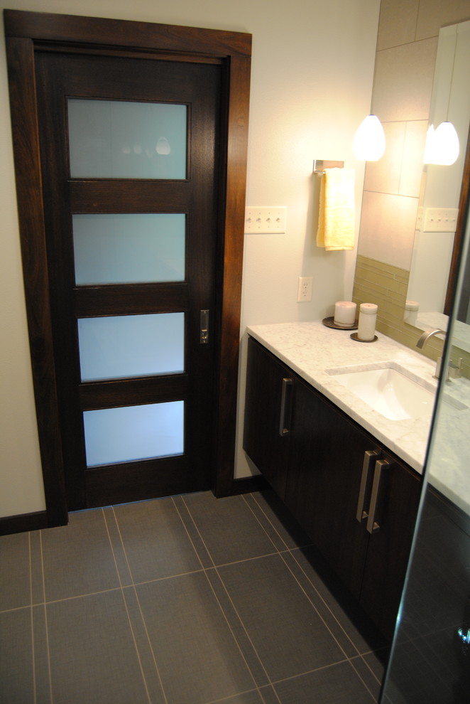 Exemple d'une salle de bain principale moderne en bois foncé de taille moyenne avec un lavabo encastré, un placard à porte plane, un plan de toilette en marbre, une douche d'angle, WC séparés, un carrelage gris, un mur gris et un sol en carrelage de porcelaine.