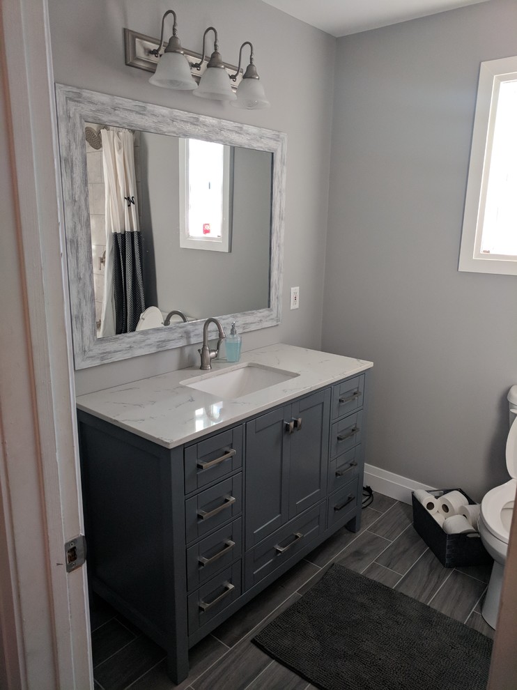 Immagine di una stanza da bagno minimal con ante grigie, pareti grigie, pavimento grigio e top bianco