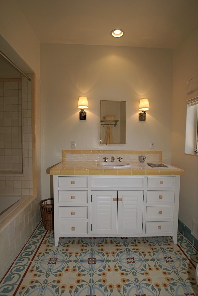 Пример оригинального дизайна: маленькая главная ванная комната в стиле ретро с накладной раковиной, фасадами островного типа, ванной в нише, душем в нише, разноцветной плиткой, цементной плиткой, белыми стенами и полом из мозаичной плитки для на участке и в саду