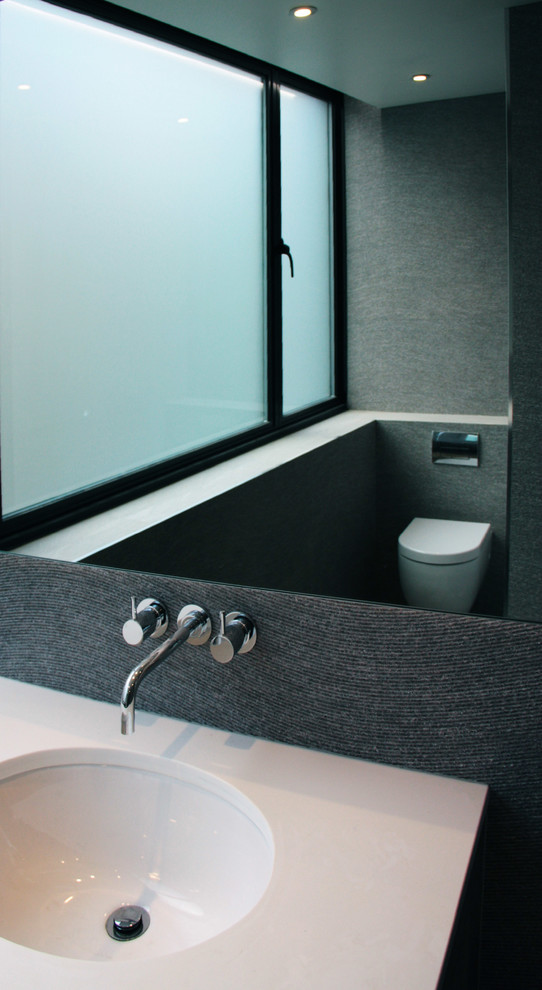Idee per una stanza da bagno moderna di medie dimensioni con doccia a filo pavimento, WC sospeso, piastrelle grigie, piastrelle in ceramica, pareti grigie, pavimento in ardesia, lavabo sottopiano e top in quarzo composito