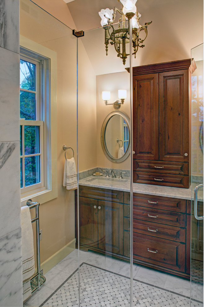 Bild på ett stort vintage grå grått en-suite badrum, med luckor med upphöjd panel, skåp i mörkt trä, en dusch i en alkov, en toalettstol med separat cisternkåpa, beige väggar, marmorgolv, ett nedsänkt handfat, marmorbänkskiva, grått golv och dusch med gångjärnsdörr