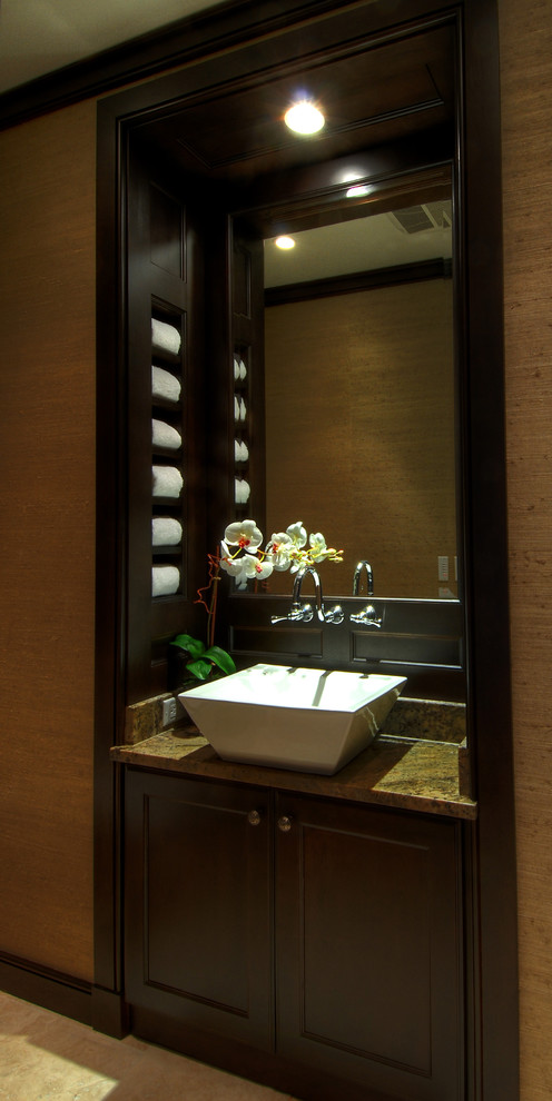 Cette image montre une salle d'eau design en bois foncé de taille moyenne avec une vasque, un placard à porte plane, un plan de toilette en granite et un sol en marbre.