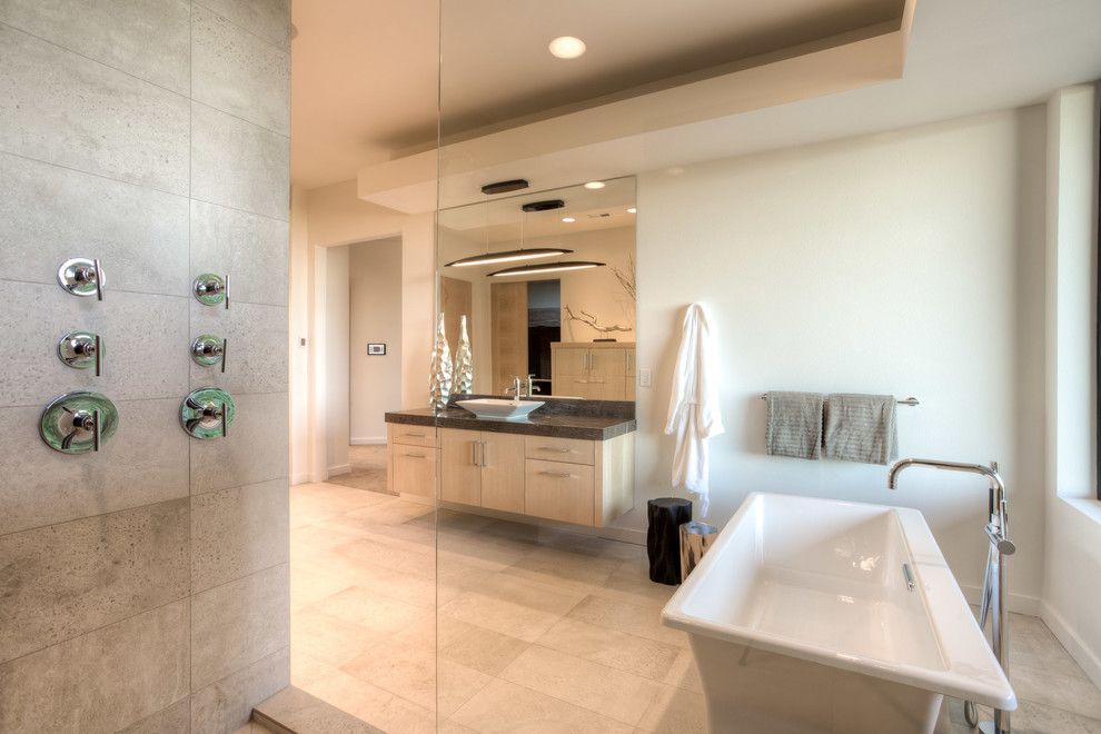Ejemplo de cuarto de baño principal contemporáneo grande con armarios con paneles lisos, puertas de armario de madera clara, bañera exenta y suelo de baldosas de cerámica