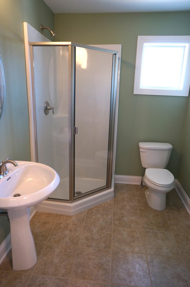 Inspiration för ett mellanstort vintage badrum, med ett piedestal handfat, en hörndusch, en toalettstol med separat cisternkåpa, beige kakel, keramikplattor, gröna väggar och klinkergolv i keramik