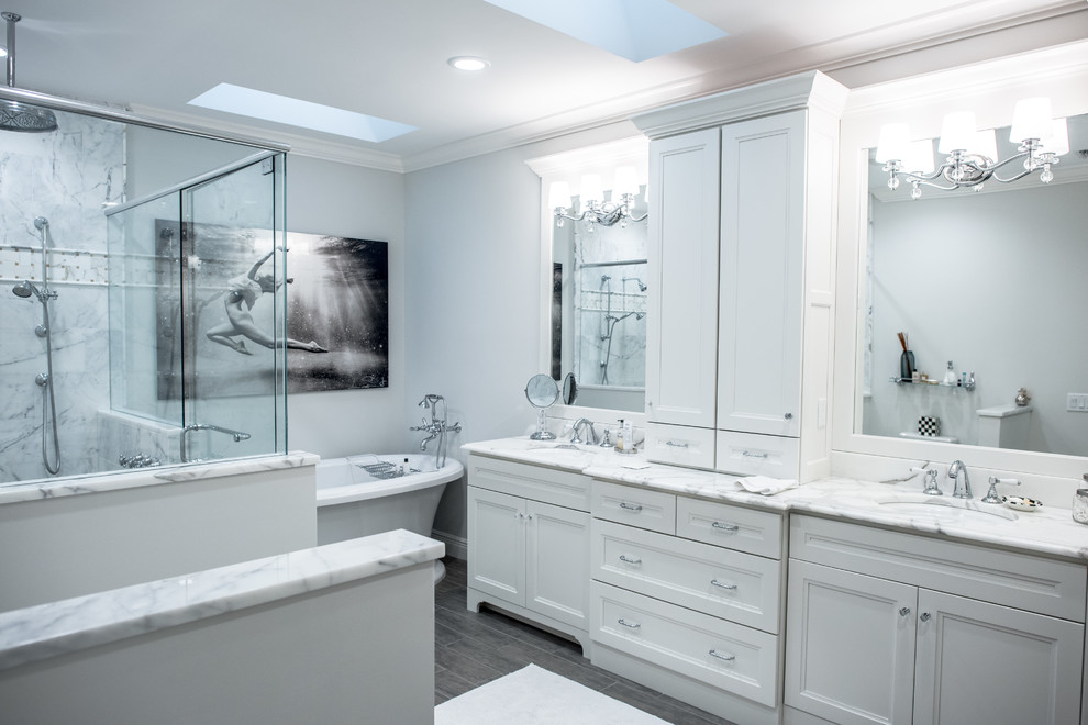 Modern inredning av ett stort en-suite badrum, med luckor med infälld panel, vita skåp, ett fristående badkar, en dusch i en alkov, en toalettstol med hel cisternkåpa, grå kakel, vit kakel, porslinskakel, vita väggar, klinkergolv i porslin, ett undermonterad handfat och marmorbänkskiva