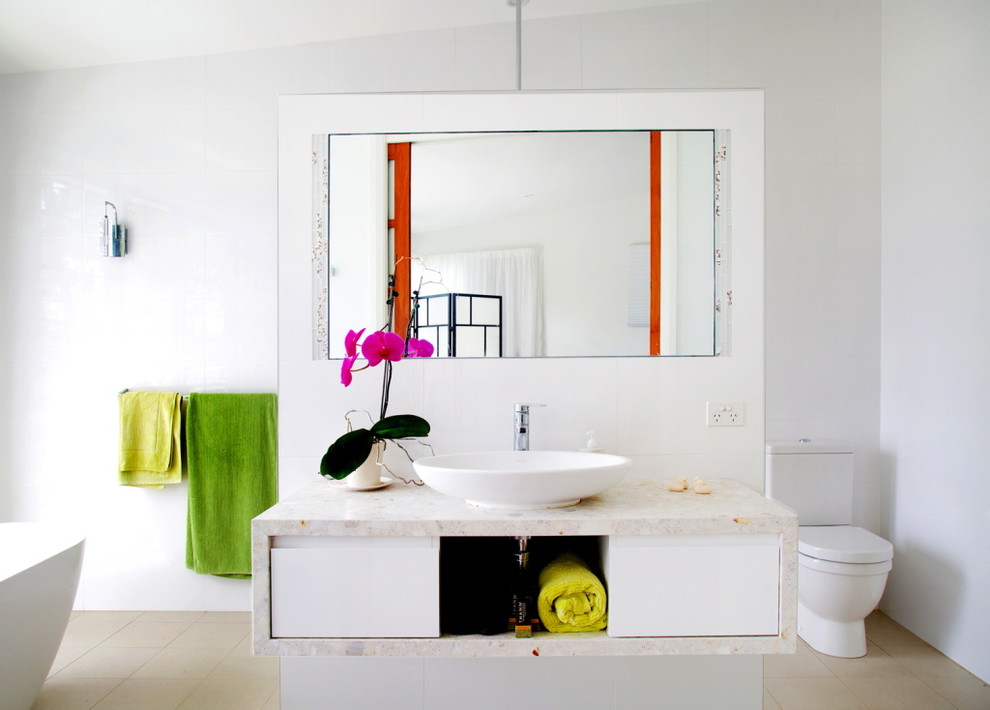 Imagen de cuarto de baño principal contemporáneo con armarios con paneles lisos, bañera exenta, sanitario de dos piezas, paredes blancas y lavabo sobreencimera