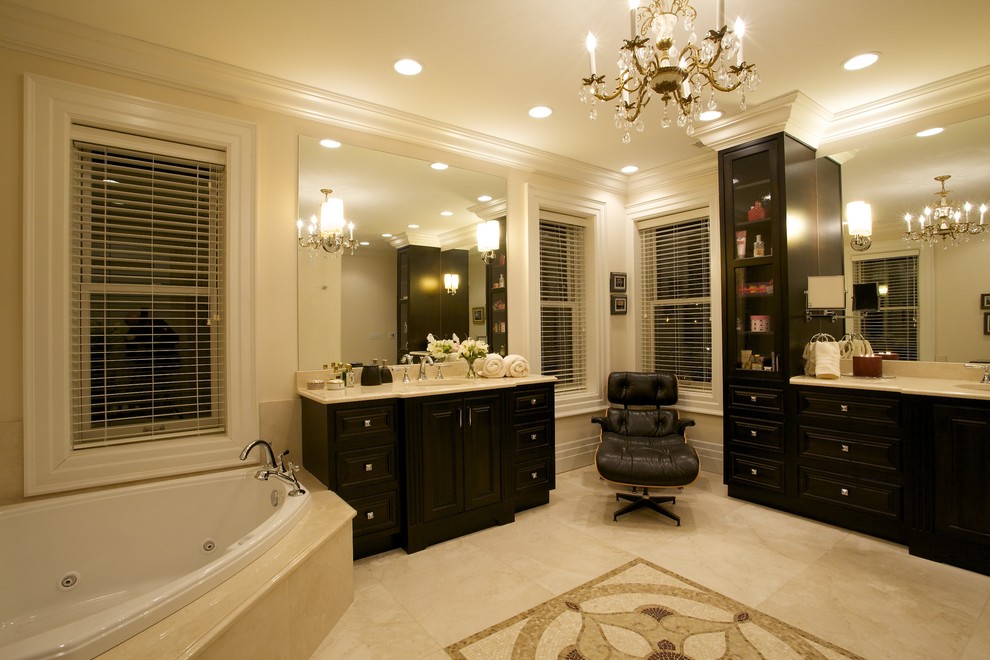 Aménagement d'une salle de bain classique en bois foncé avec un lavabo encastré, une baignoire d'angle, un carrelage beige, un plan de toilette en marbre, une douche ouverte, WC à poser, un mur beige, un sol en marbre et un placard avec porte à panneau surélevé.