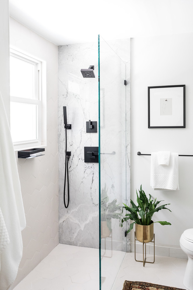 Modern inredning av ett mellanstort grå grått badrum med dusch, med släta luckor, svarta skåp, en hörndusch, en toalettstol med hel cisternkåpa, grå kakel, vit kakel, marmorkakel, vita väggar, ett undermonterad handfat, marmorbänkskiva, vitt golv och med dusch som är öppen