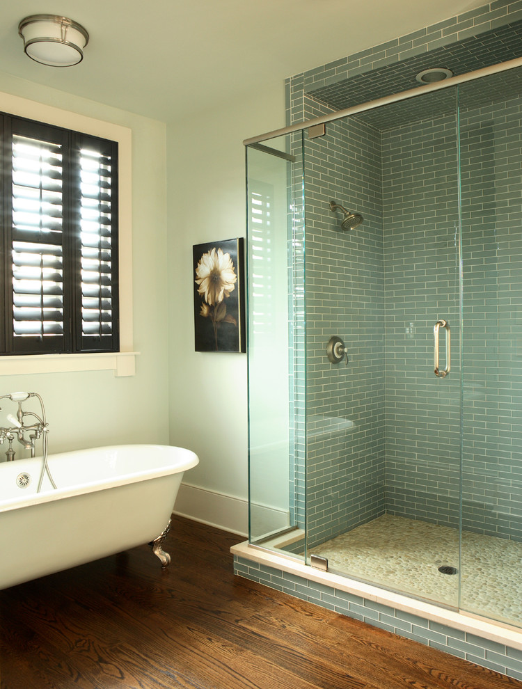 На фото: ванная комната в классическом стиле с ванной на ножках и коричневым полом с