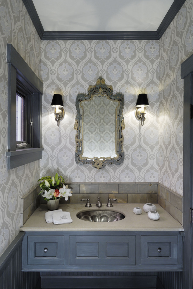 Immagine di una stanza da bagno contemporanea con lavabo sottopiano, ante blu e pareti multicolore