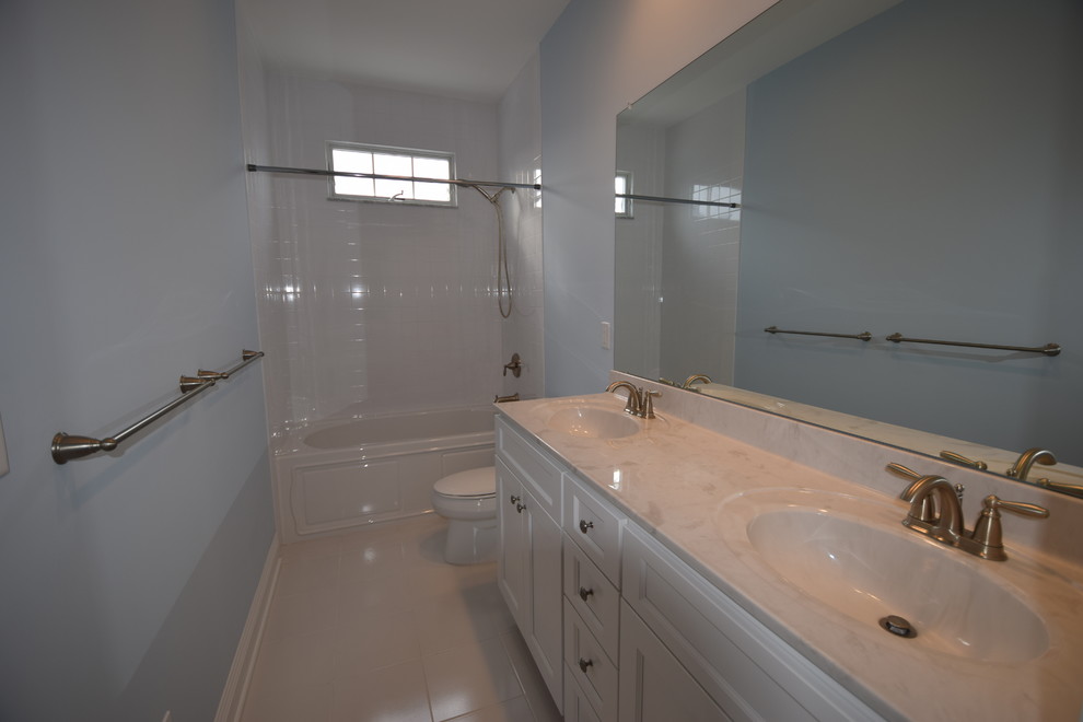 Inspiration för ett maritimt badrum, med luckor med infälld panel, vita skåp, blå väggar och ett integrerad handfat