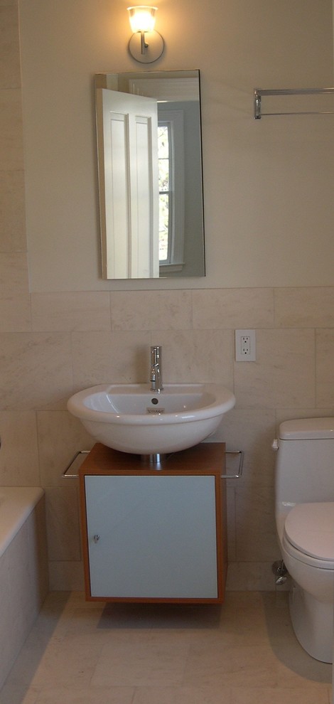 Drop-in bathtub - mid-sized modern master beige tile and limestone tile limestone floor and white floor drop-in bathtub idea in Boston with flat-panel cabinets, medium tone wood cabinets, a one-piece toilet, beige walls, a drop-in sink and marble countertops