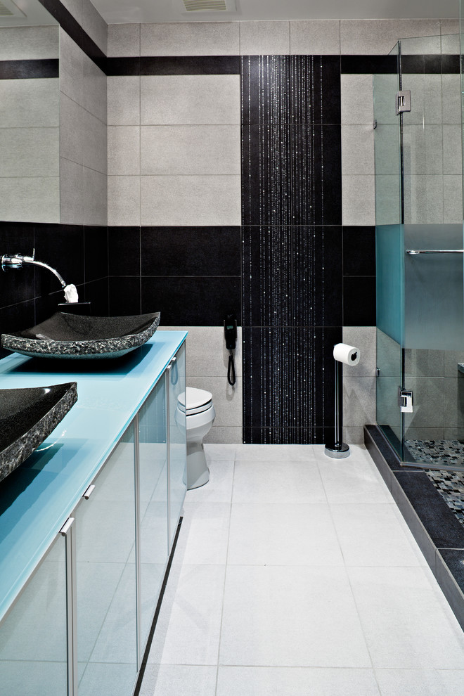 Bild på ett mellanstort eklektiskt en-suite badrum, med ett fristående handfat, släta luckor, en dusch i en alkov, en toalettstol med separat cisternkåpa, grå väggar, bänkskiva i glas och vitt golv