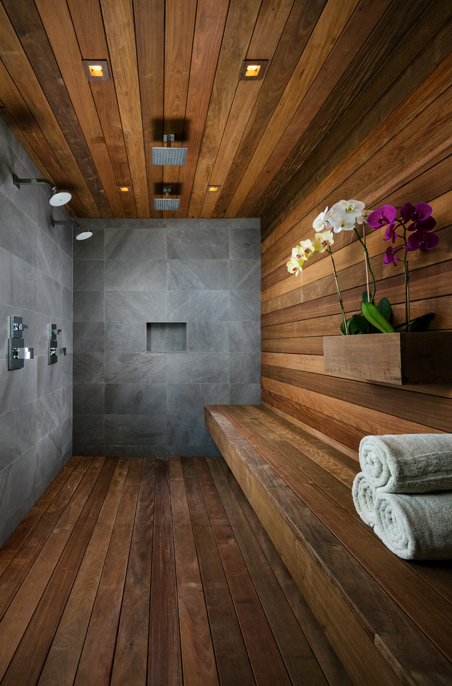 Idée de décoration pour une grande salle de bain principale design avec une douche double, une baignoire indépendante, un mur beige, parquet foncé, une vasque, un plan de toilette en bois, un sol marron et aucune cabine.
