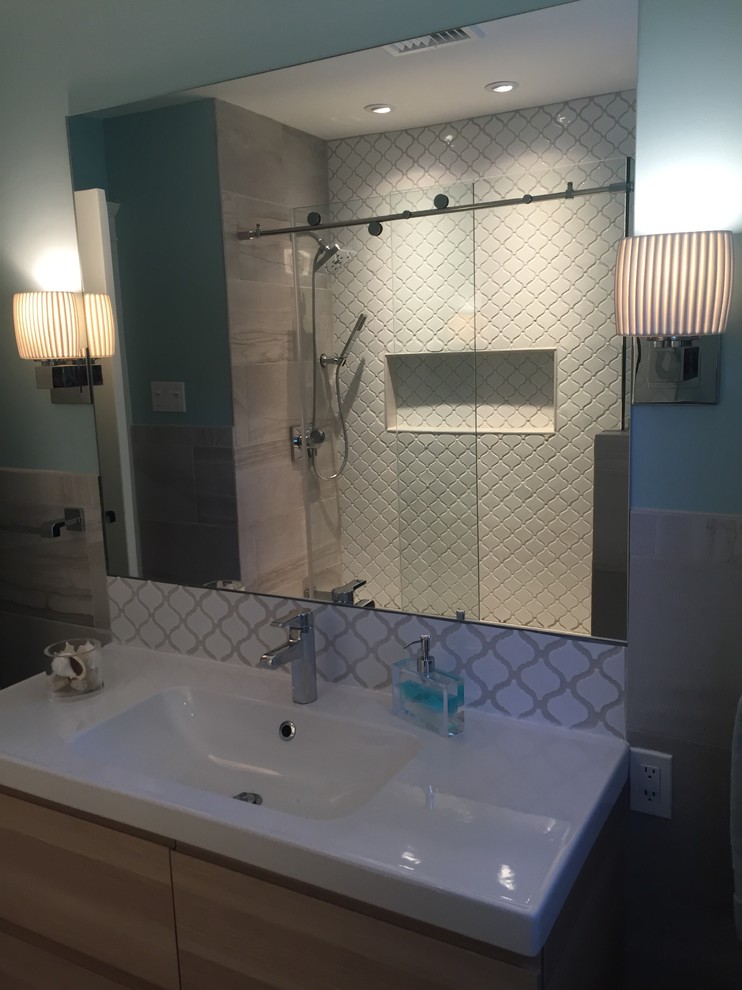 Kleines Modernes Badezimmer mit flächenbündigen Schrankfronten, Einbaubadewanne, weißen Fliesen, Porzellanfliesen, Porzellan-Bodenfliesen und Schiebetür-Duschabtrennung in New York