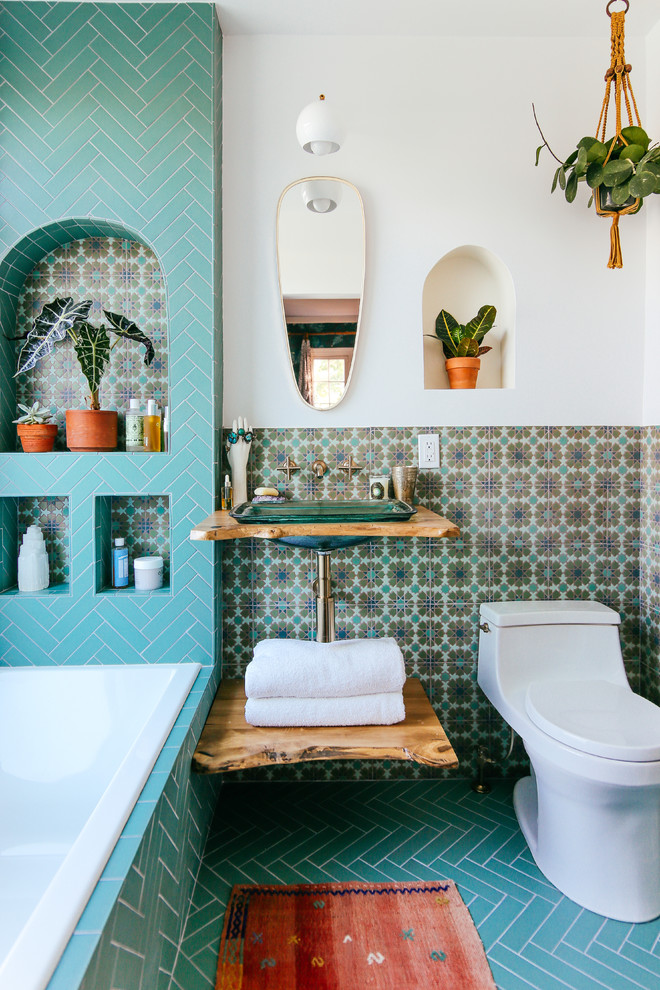 Пример оригинального дизайна: ванная комната в средиземноморском стиле с душем над ванной, зеленой плиткой, керамической плиткой, белыми стенами, полом из керамической плитки, раковиной с пьедесталом, столешницей из дерева, зеленым полом и открытым душем