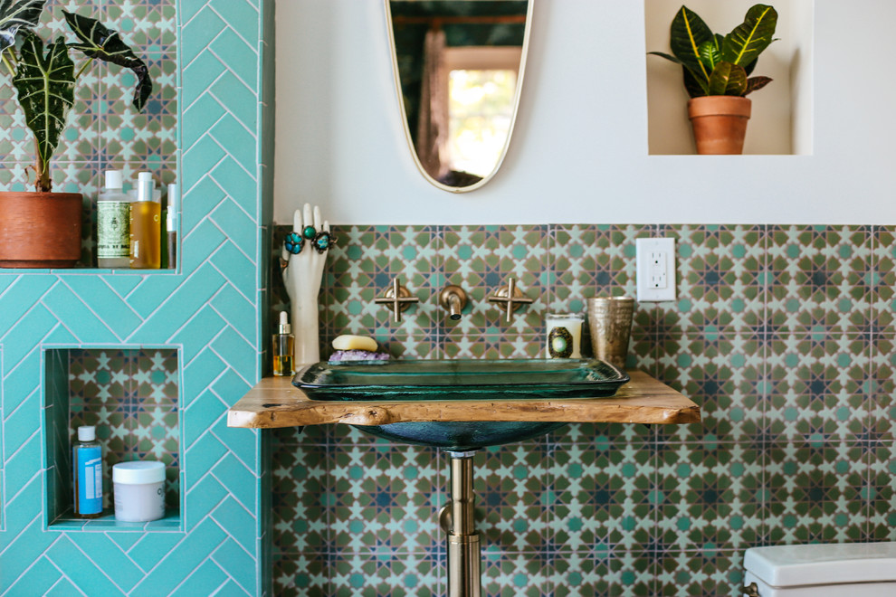 Inspiration för ett medelhavsstil brun brunt badrum, med en dusch/badkar-kombination, grön kakel, keramikplattor, vita väggar, klinkergolv i keramik, ett piedestal handfat, träbänkskiva, grönt golv och med dusch som är öppen