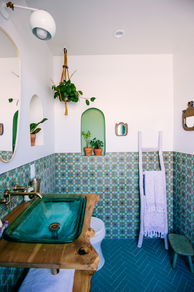 Идея дизайна: ванная комната в средиземноморском стиле с душем над ванной, зеленой плиткой, керамической плиткой, белыми стенами, полом из керамической плитки, раковиной с пьедесталом, столешницей из дерева, зеленым полом и открытым душем