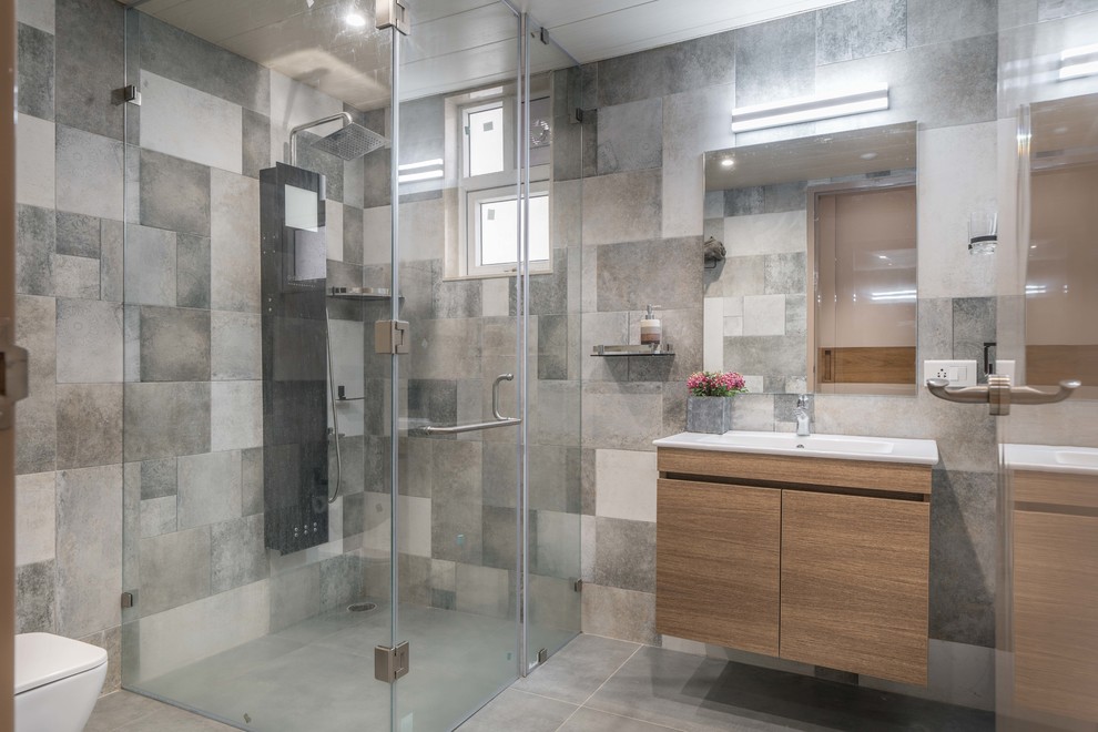Idée de décoration pour une salle d'eau design en bois brun avec un placard à porte plane, une douche à l'italienne, un carrelage gris, un lavabo intégré, un sol gris, une cabine de douche à porte battante et un plan de toilette blanc.