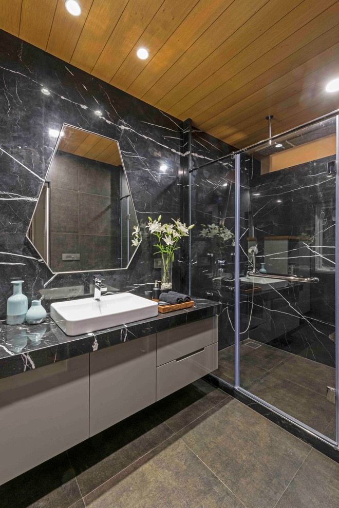 Modernes Badezimmer mit flächenbündigen Schrankfronten, beigen Schränken, Eckdusche, grauer Wandfarbe, Aufsatzwaschbecken, Schiebetür-Duschabtrennung, grauer Waschtischplatte und braunem Boden in Ahmedabad