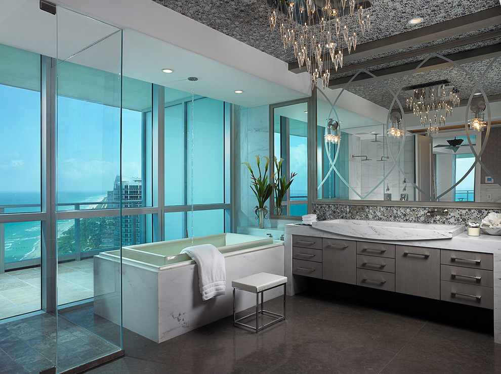 Mid-sized beach style master porcelain tile bathroom photo in Miami with furniture-like cabinets, beige cabinets, white walls, a trough sink, marble countertops and a hinged shower door