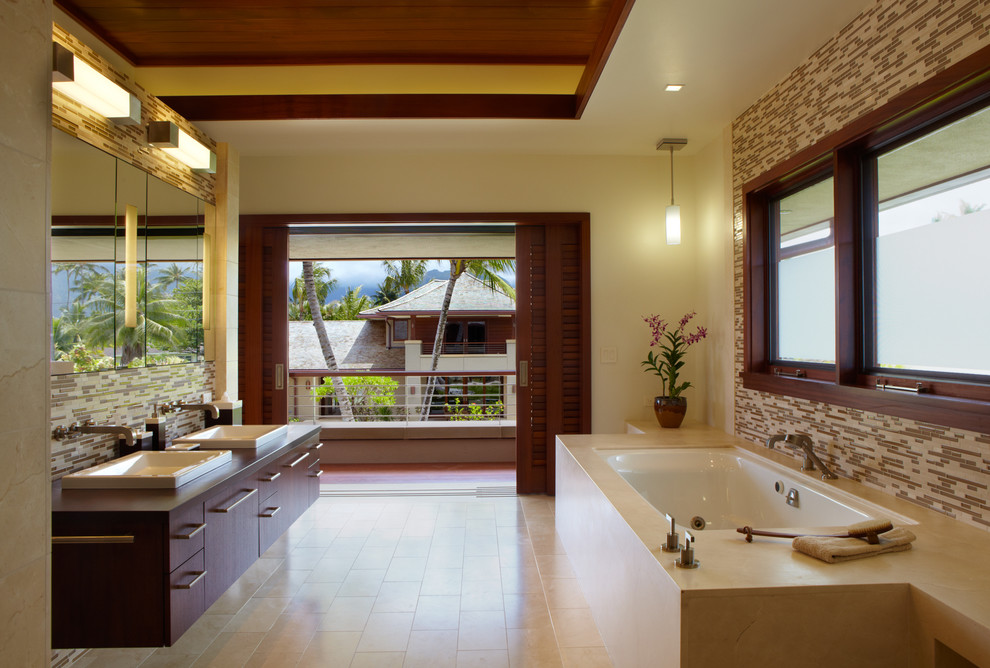Exemple d'une salle de bain principale exotique en bois foncé avec un placard à porte plane et un plan de toilette en bois.