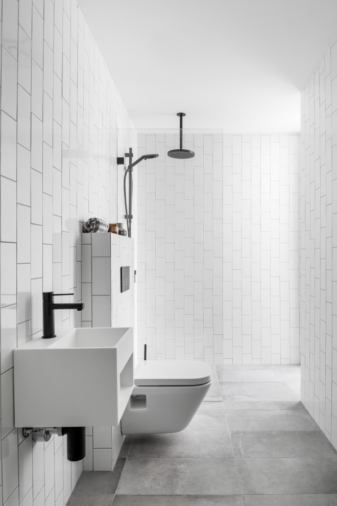 Cette photo montre une salle de bain tendance avec une douche à l'italienne, un carrelage blanc, un carrelage métro, un lavabo suspendu, un sol gris, aucune cabine et meuble simple vasque.