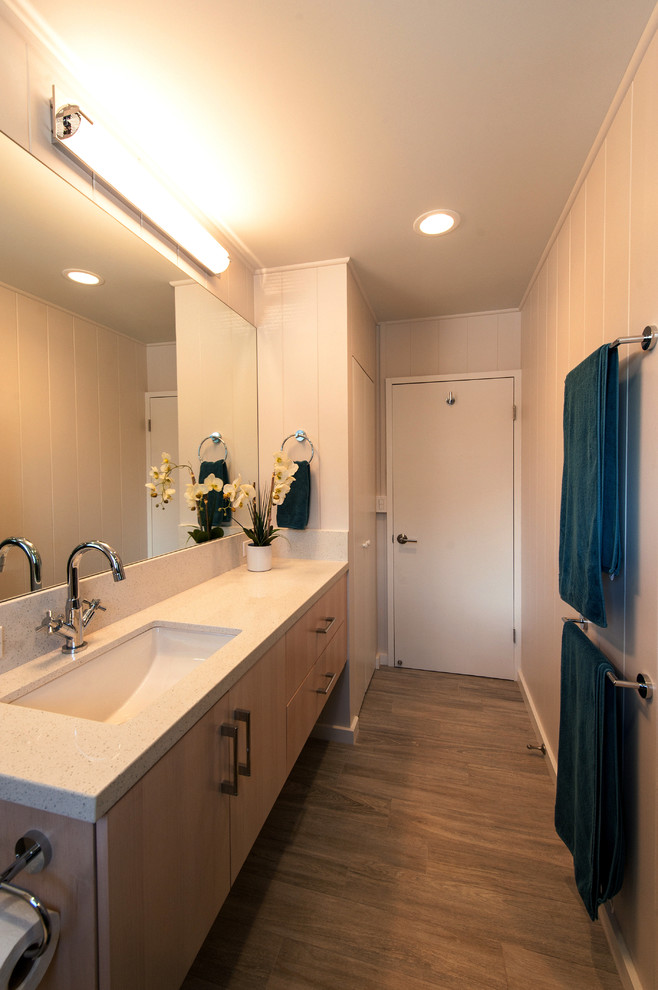На фото: ванная комната в стиле неоклассика (современная классика) с врезной раковиной, плоскими фасадами, светлыми деревянными фасадами, столешницей из кварцита, раздельным унитазом, стеклянной плиткой, белыми стенами, полом из бамбука и душевой кабиной