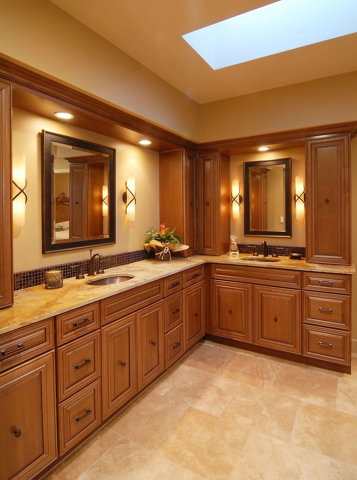 Exemple d'une salle de bain principale méditerranéenne en bois brun de taille moyenne avec un placard avec porte à panneau surélevé, un carrelage marron, mosaïque, un mur beige, un sol en travertin, un lavabo encastré, un plan de toilette en onyx et un sol beige.