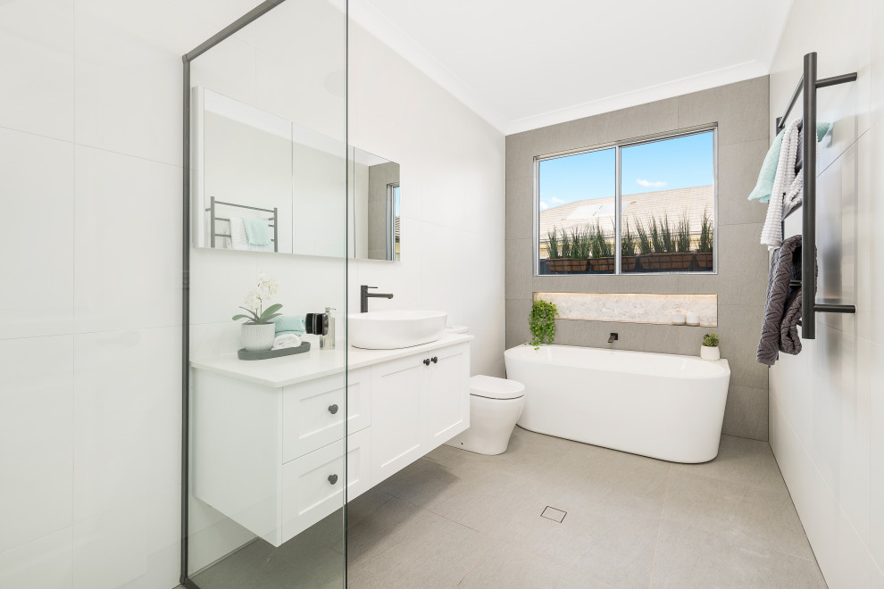 Modernes Badezimmer mit Schrankfronten im Shaker-Stil, weißen Schränken, freistehender Badewanne, Aufsatzwaschbecken, grauem Boden und weißer Waschtischplatte in Sydney