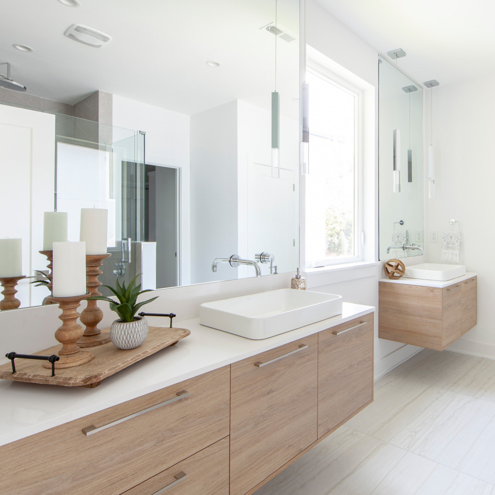 Design ideas for a contemporary ensuite bathroom in Charlotte with flat-panel cabinets, a vessel sink, engineered stone worktops, white worktops, light wood cabinets, white walls and beige floors.